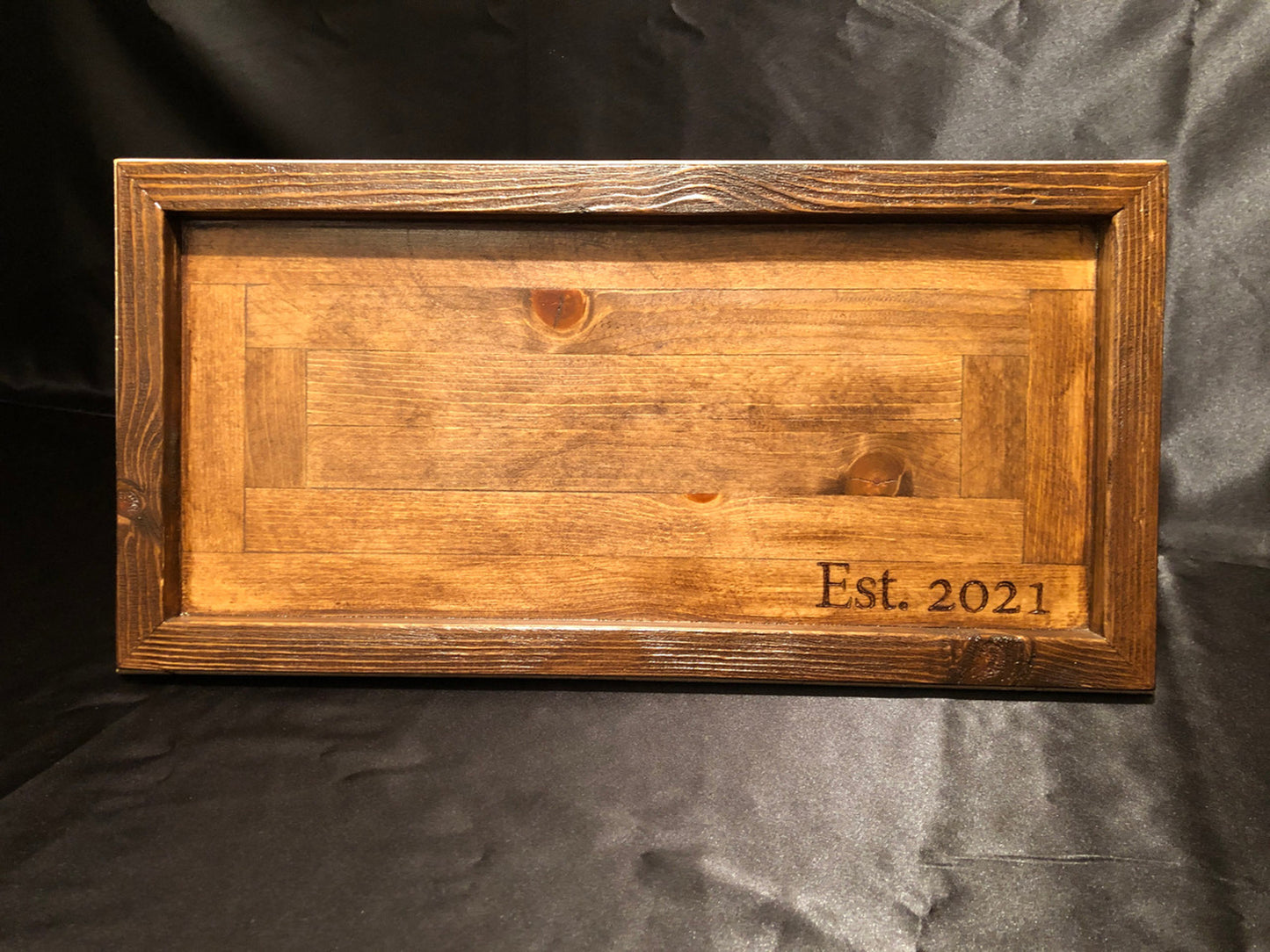 Front view of solid wood charcuterie board with "Est. 2021" personalization against black background