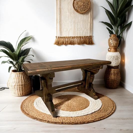 A solid wood garden bench with beautiful grain texture placed on a round area rug in an indoor setting, accompanied by decorative plants and vases.