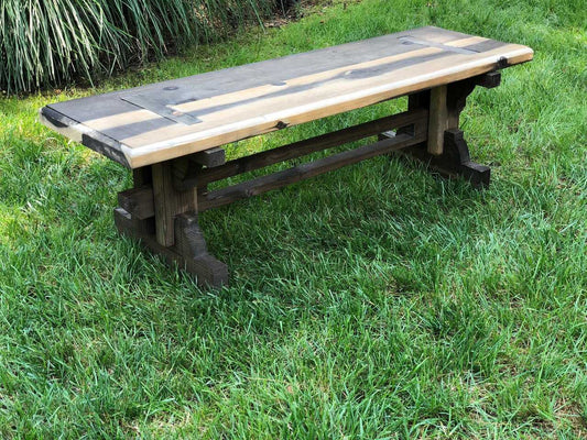 A contemporary thermally modified solid wood garden bench with a natural finish, featuring effortless hardware-free assembly placed in a grassy field.