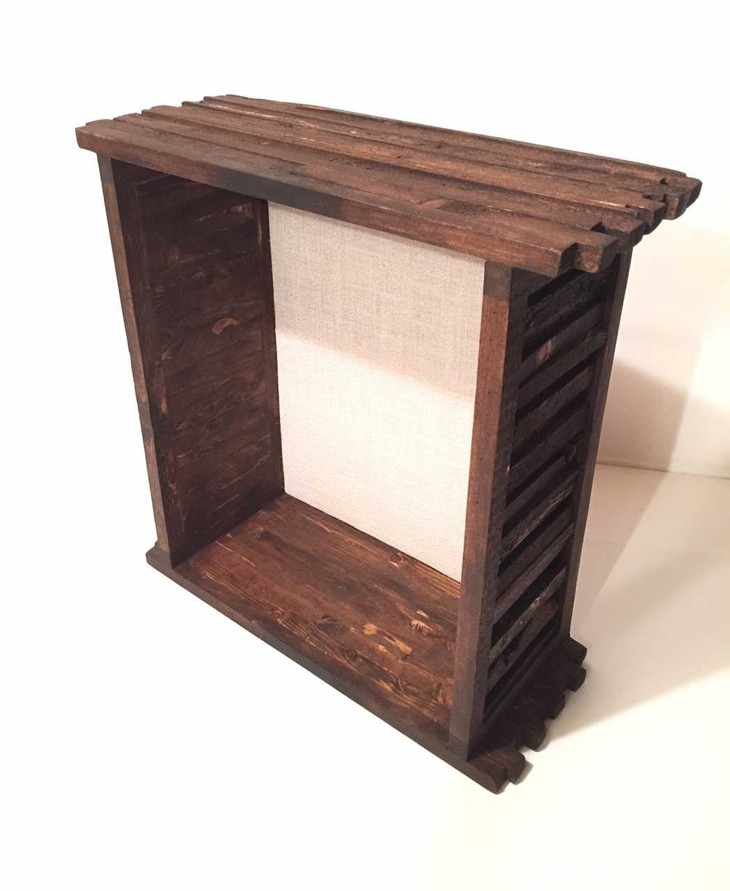 A brown wooden deep display case with a shingled wood frame and burlap backing.