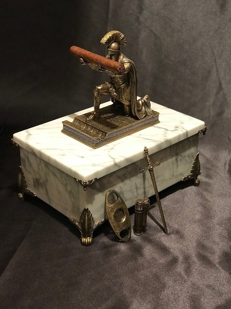 A White Carrara Marble Humidor featuring an antiqued Spartan statue lid handle afixed to marble lid on a black satin background.